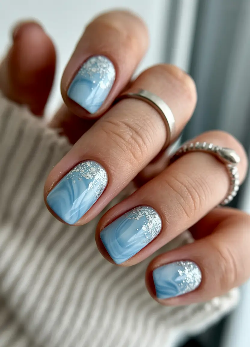 April nails ideas 2026 Short blue marble nails with shimmering silver accents