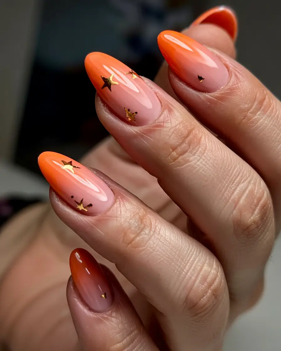 vibrant spring orange nails 2026 Peach to Orange Ombre Almond with Gold Stars