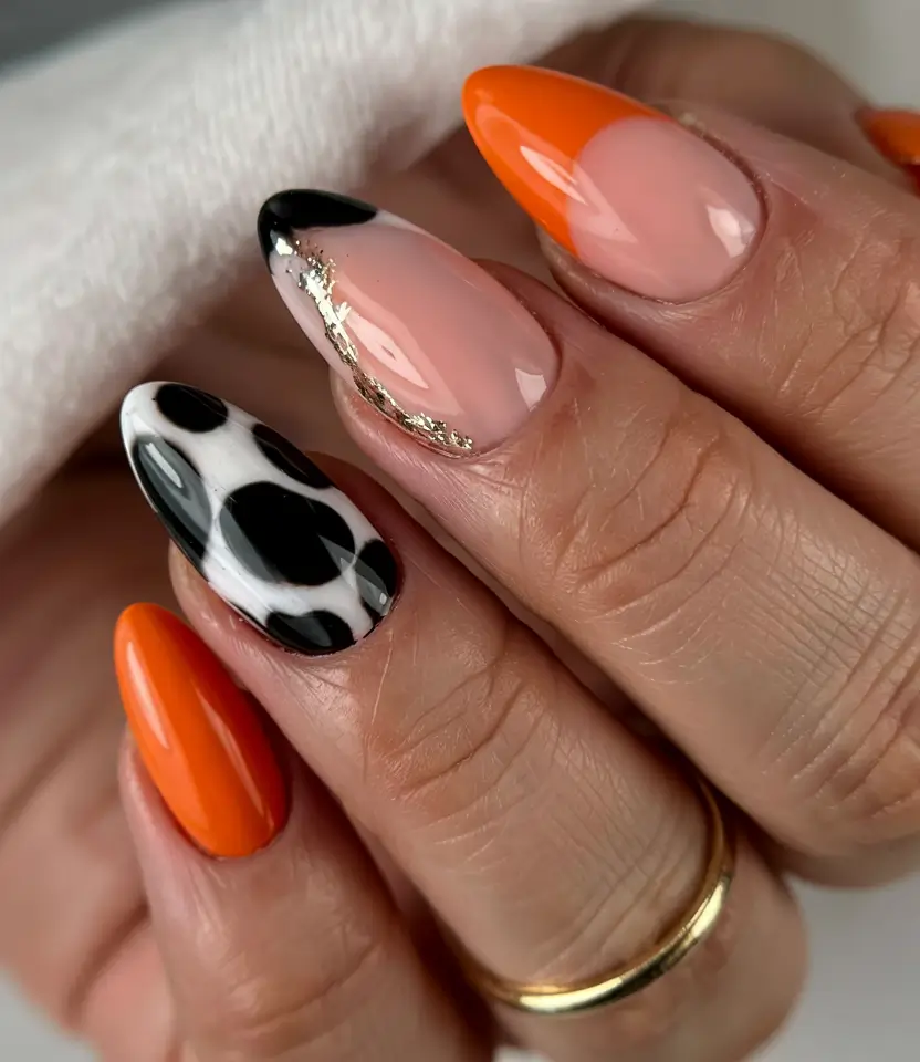 vibrant spring orange nails 2026 Bold Orange with Graphic Cow Print Accent