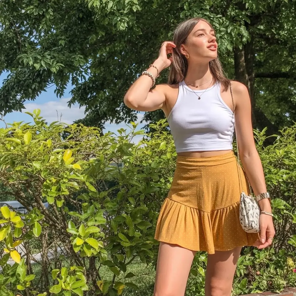 summer crop top outfits for women 2026 Soft white crop top and golden mini skirt summer glow