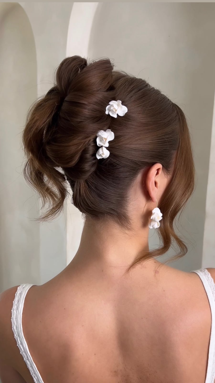 Voluminous Dark Brown Bun With Floral Pins Voluminous Dark Brown Bun With Floral Pins — Classy Bridal Bun
