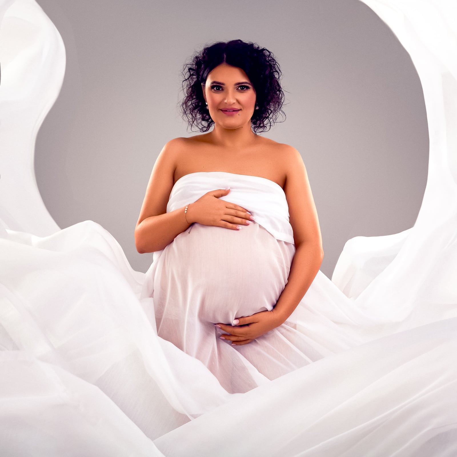 Swirling White Draped Fabric With Possibly Chiffon Or Tulle Swirling White Draped Fabric With Possibly Chiffon Or Tulle — Classy Maternity Photoshoot Outfits