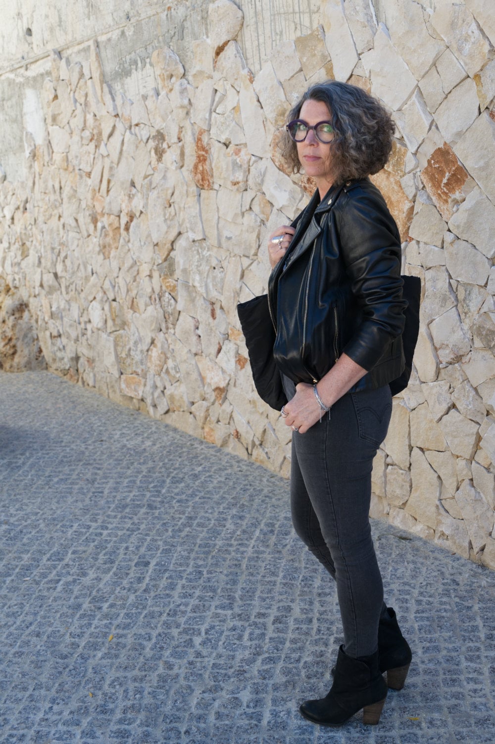 Black Leather Jacket Over a Gray Top and Charcoal Jeans Black Leather Jacket Over a Gray Top and Charcoal Jeans — Elegant Rock Outfits