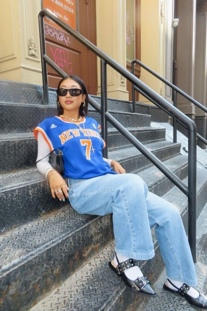 Blue Basketball Jersey Over Long Sleeve Shirt with Wide Leg Jeans — Simple Basketball Game Outfits