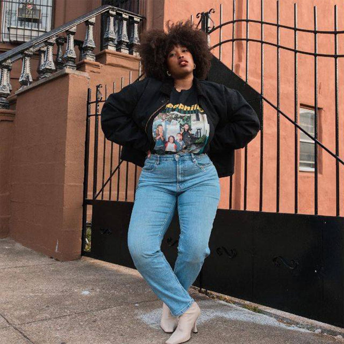 Black Bomber Jacket Over a Graphic T-Shirt and Baggy Jeans — Trendy 90s Style