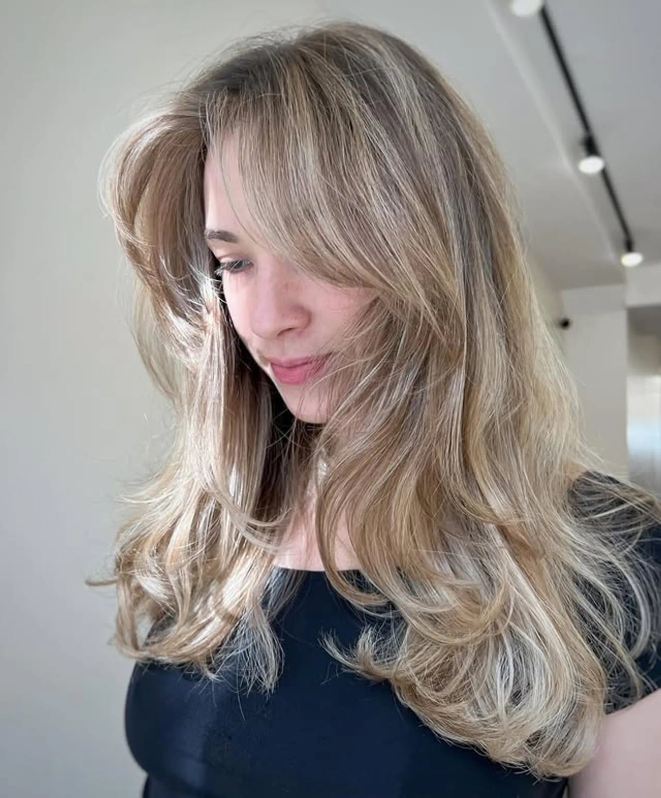Collarbone Ash Blonde Layered Bob With Curtain Bangs Collarbone Ash Blonde Layered Bob With Curtain Bangs — Trendy Blonde Wavy Hair