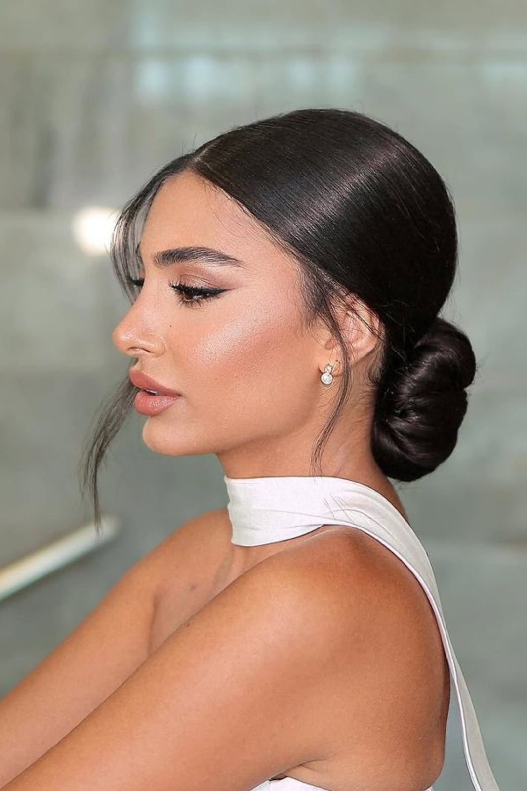 Sleek Dark Brown Low Bun With Wispy Bangs Sleek Dark Brown Low Bun With Wispy Bangs — Trendy Bridesmaid Hair Updo