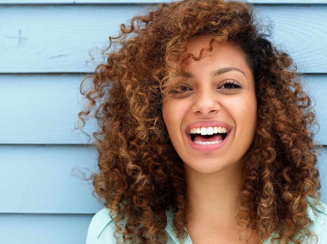 Collarbone Curls With Caramel Highlights — Trendy Brown Curly Hair