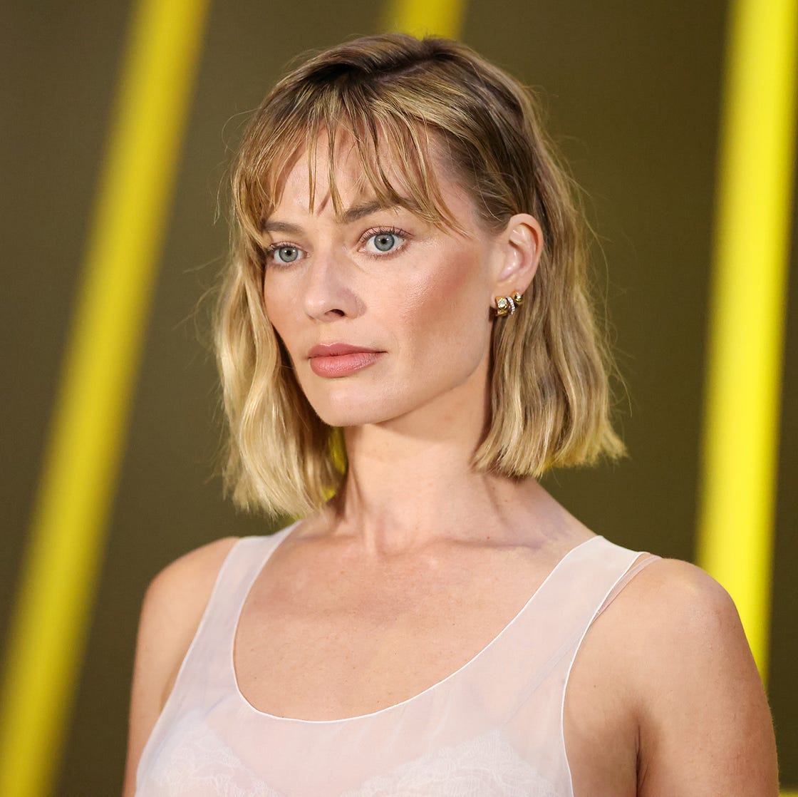 Textured Ash Blonde Bob With Curtain Bangs and Styled In Gentle Waves — Trendy Chin Length Hair