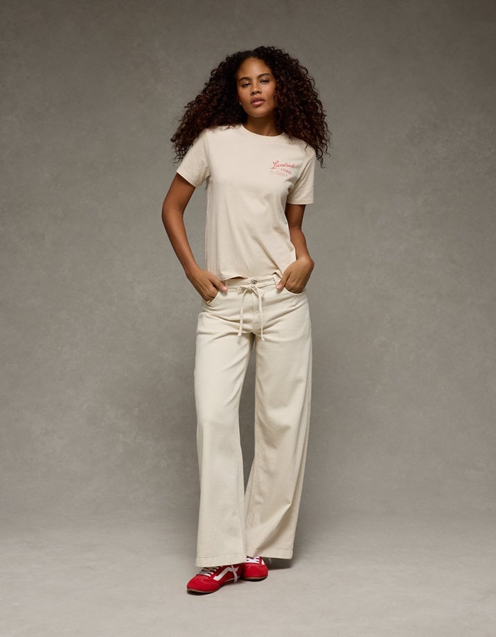 Graphic Tee With Cream Trousers And Red Sneakers — Trendy Graphic Tee Outfits