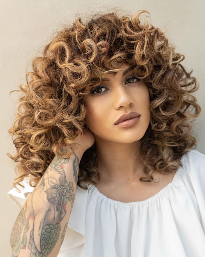 Collarbone Layers With Honey Blonde Balayage And Side Bangs Collarbone Layers With Honey Blonde Balayage And Side Bangs — Trendy Medium Curly Hair
