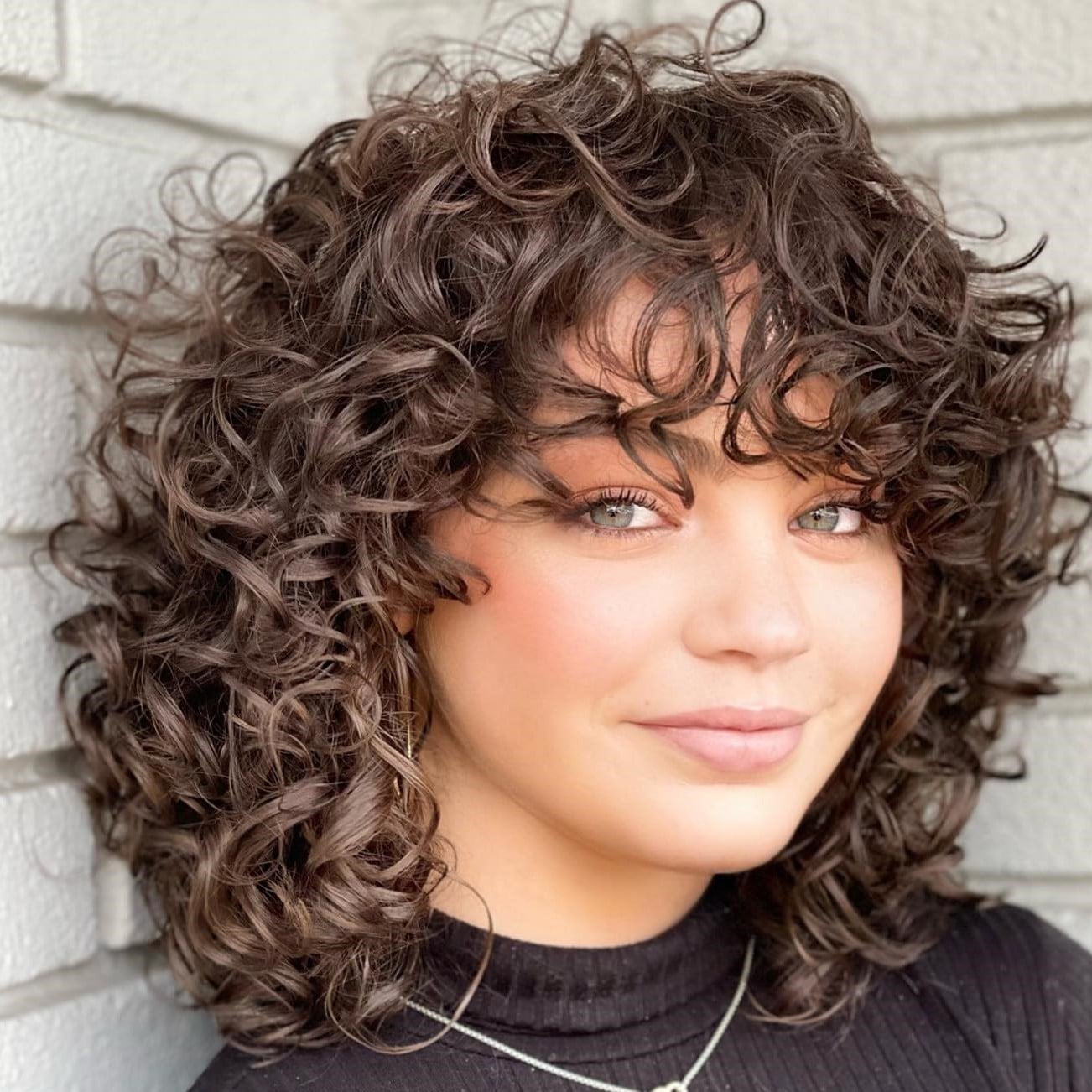 Layered Shag With Wispy Bangs And Auburn Highlights Layered Shag With Wispy Bangs And Auburn Highlights — Trendy Medium Curly Hair
