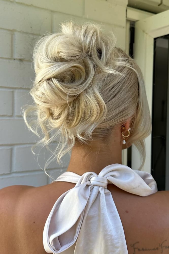 Ash Blonde Voluminous Messy Bun With Textured Curls And Loose Strands — Trendy Messy Bun Updo