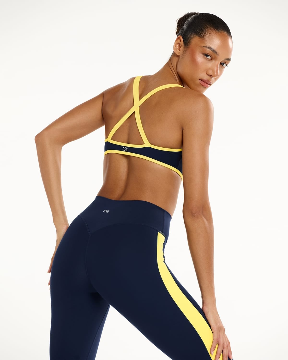 Navy Sports Bra with Yellow Trim and Striped Leggings — Trendy Pilates Outfits