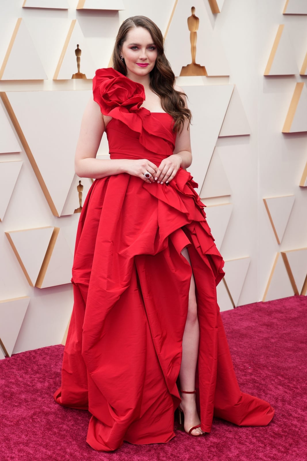 Vibrant Red Gown With Ruffled Skirt And Floral Detail — Trendy Red Carpet Outfits