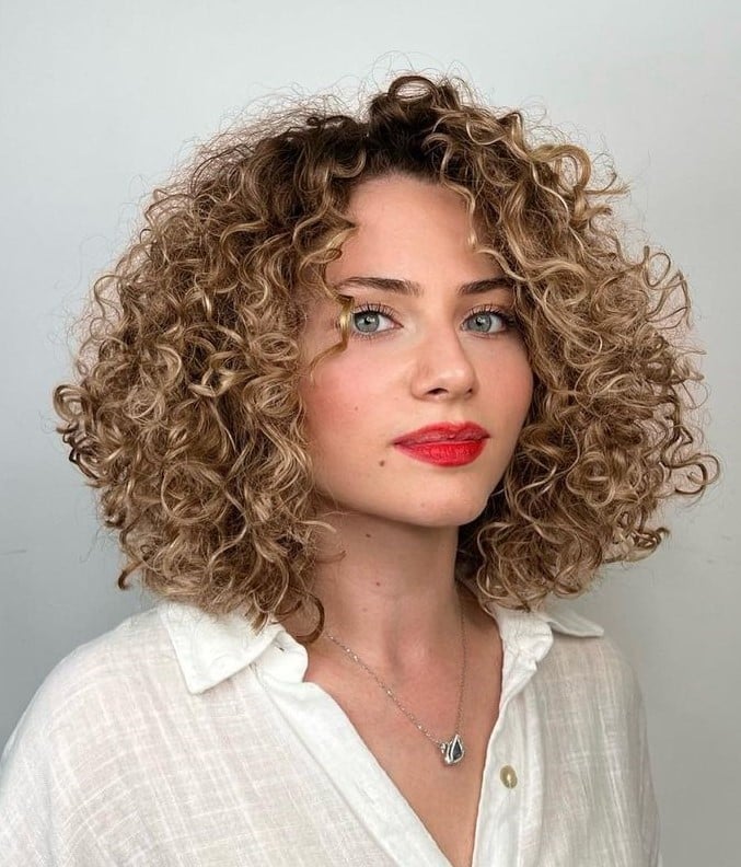 Vibrant Blonde Curls With Darker Roots — Trendy Shoulder Length Curly Hair