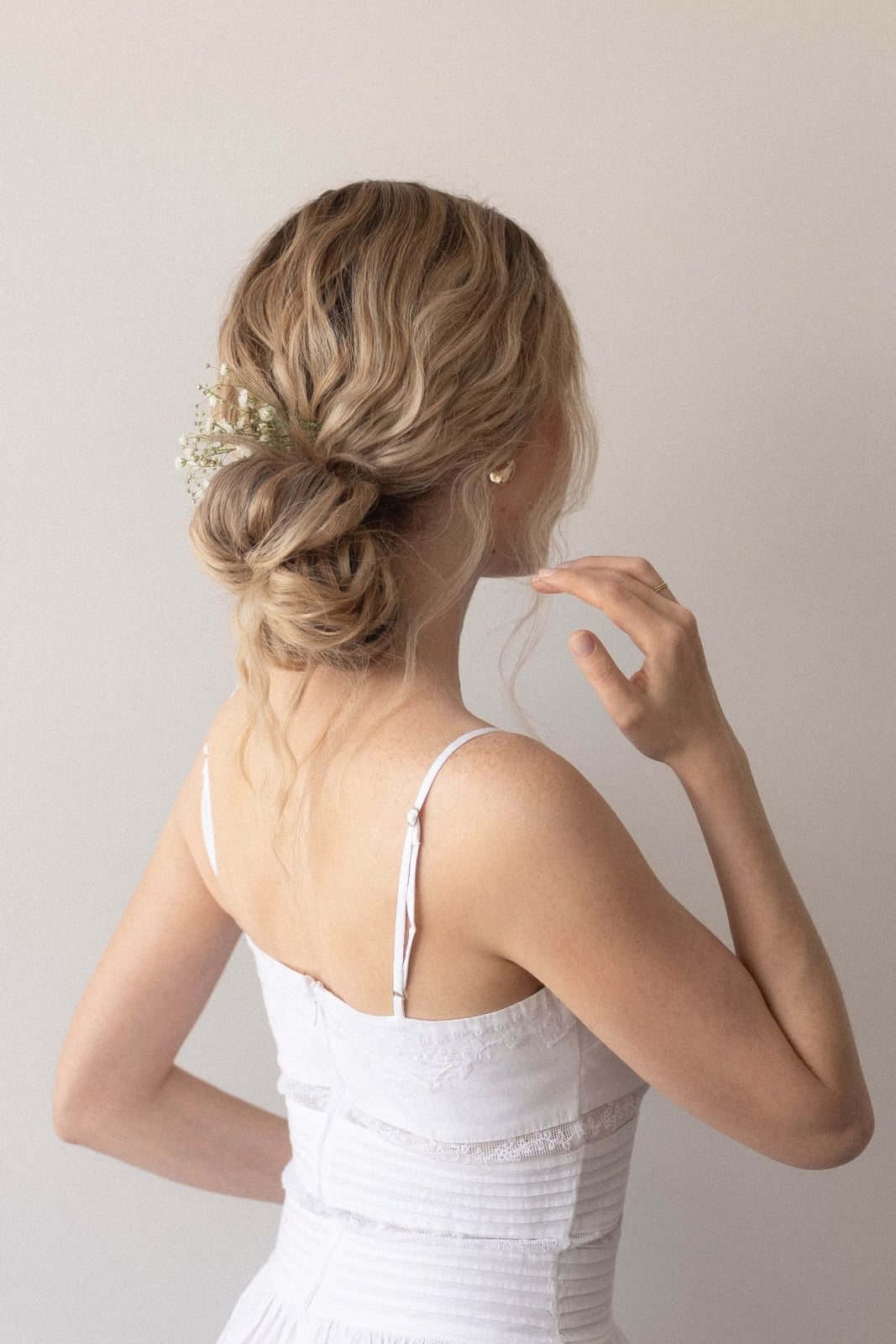 Low Blonde Bun With Delicate Flowers Low Blonde Bun With Delicate Flowers — Wedding Bun Ideas
